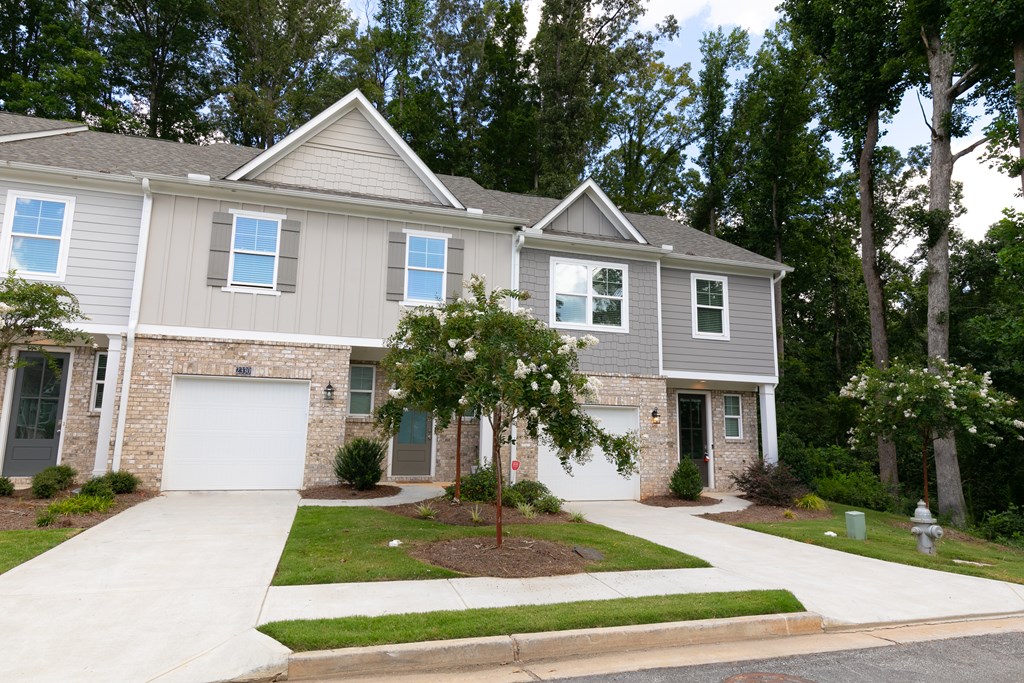 a house with two garage doors and a sidewalk in front of it