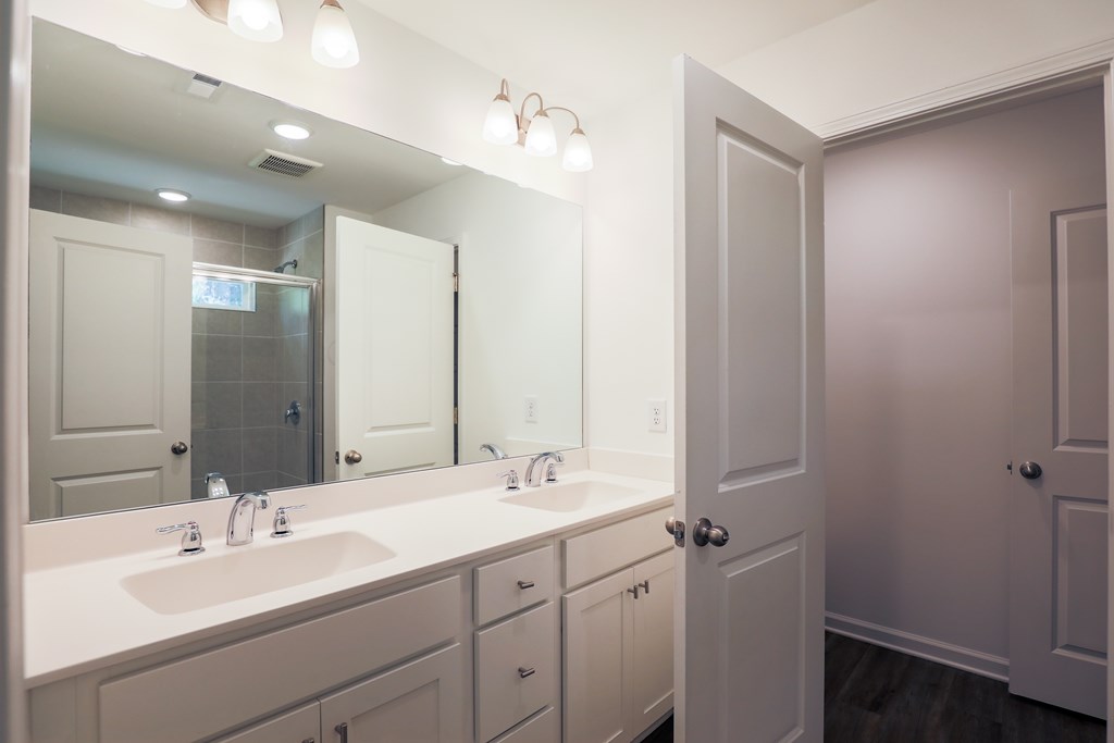 a white bathroom with two sinks and a mirror