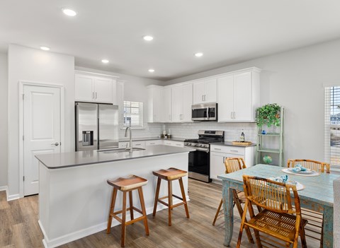 A kitchen with white cabinets and a black stove.