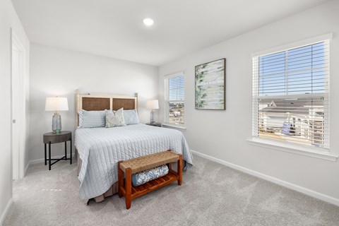 A bedroom with a bed, nightstand, and window.