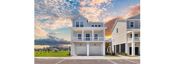 a beach house with a cloudy sky behind it