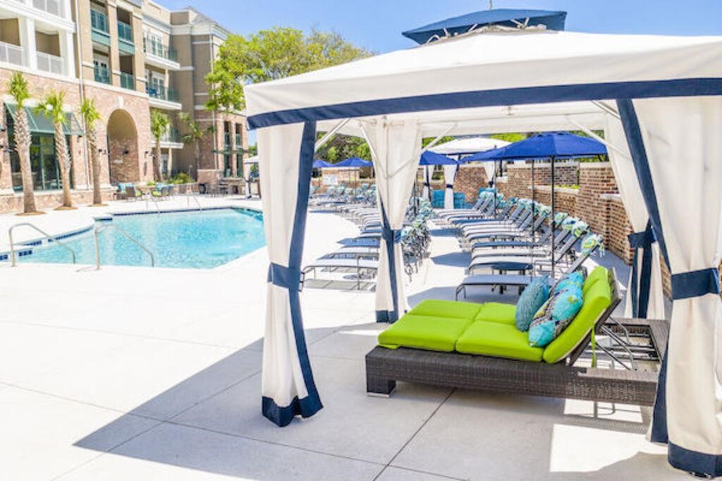 a group of lounge chairs and umbrellas near a pool
