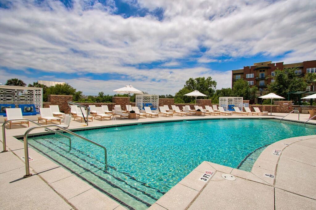 a swimming pool with lounge chairs and a building in the background
