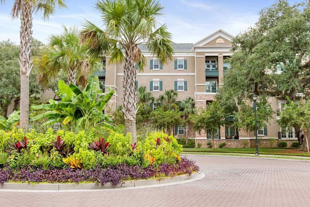 a large building with palm trees and a garden in front of it