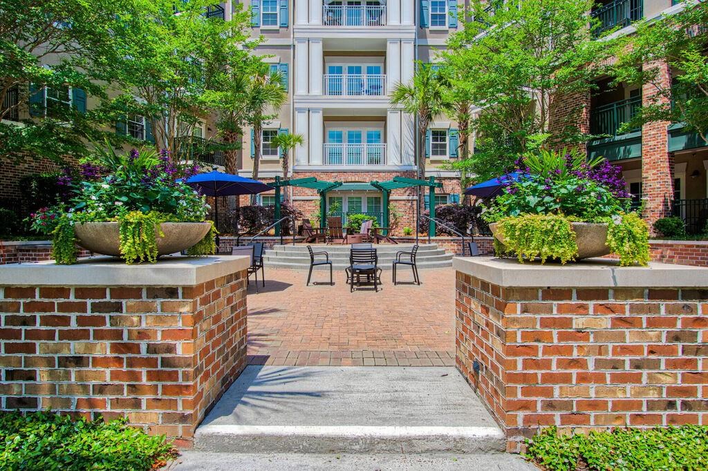 a courtyard with tables and chairs in front of a building