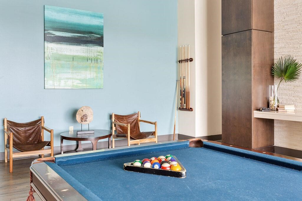 a pool table in a living room with a bunch of balls