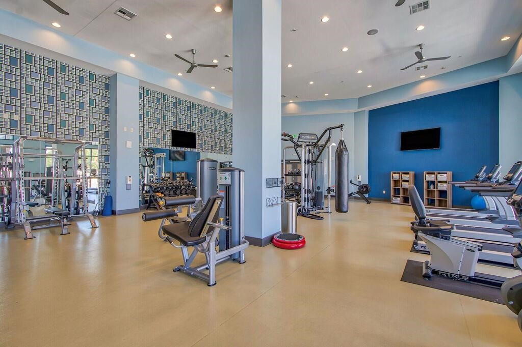 a gym with cardio equipment and weights in a building with blue walls
