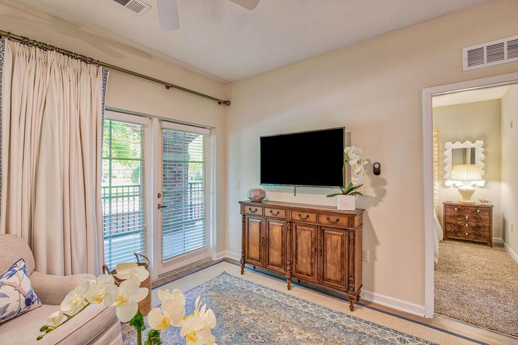 a living room with a tv and a door to a balcony