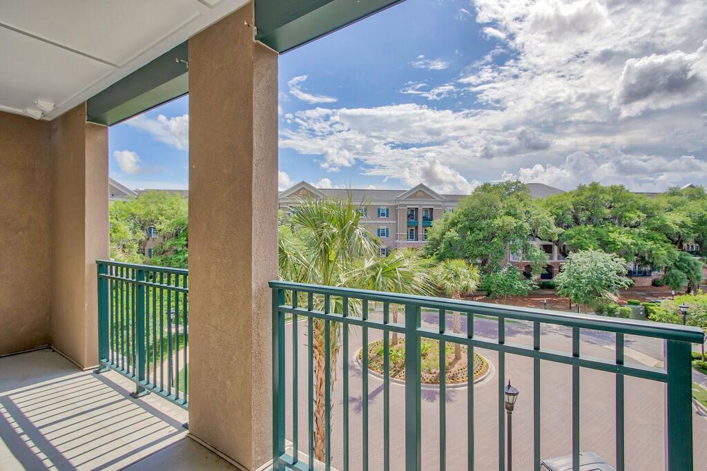 a balcony with a view of a courtyard and some trees