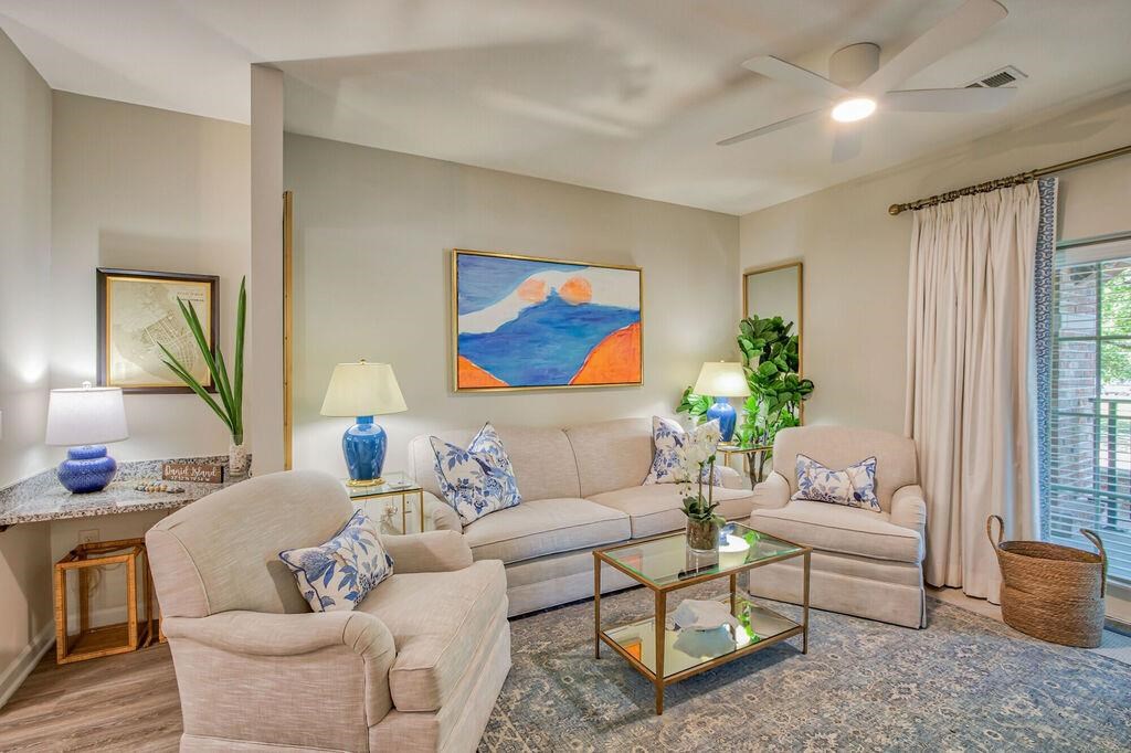 a living room with a couch and chairs and a ceiling fan