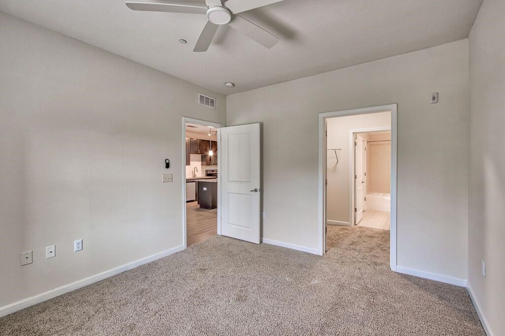 an empty living room with a ceiling fan