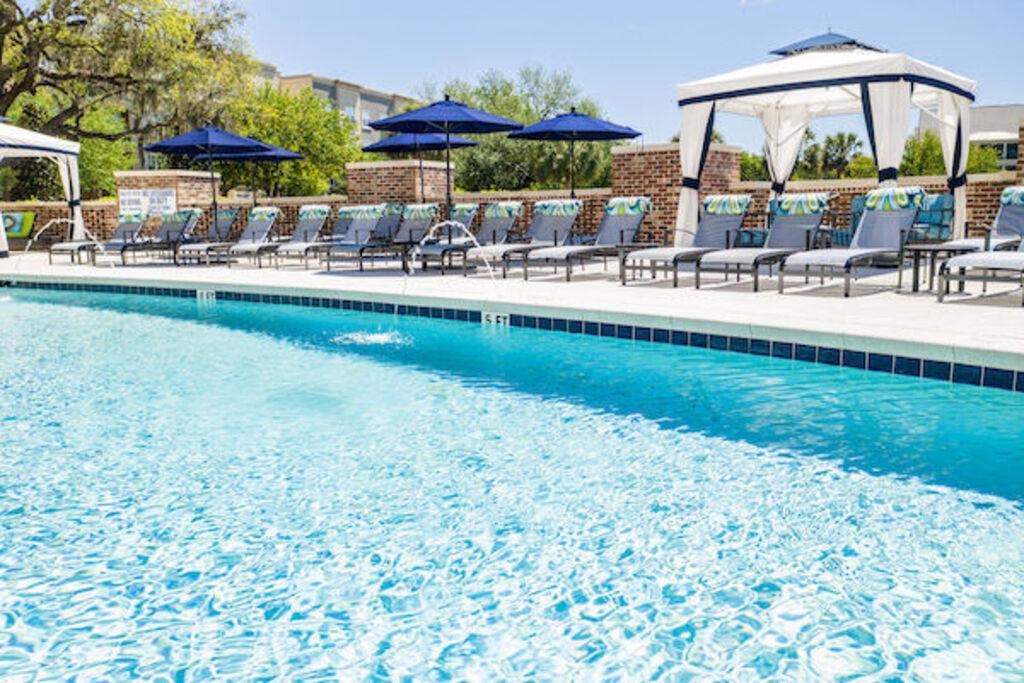 a large swimming pool with chairs and umbrellas