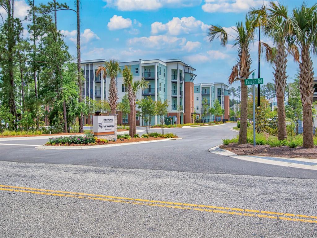 an empty street in front of an apartment building with palm trees