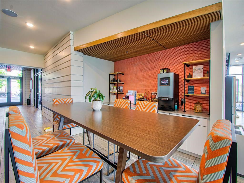 a dining room with orange and white chairs and a table