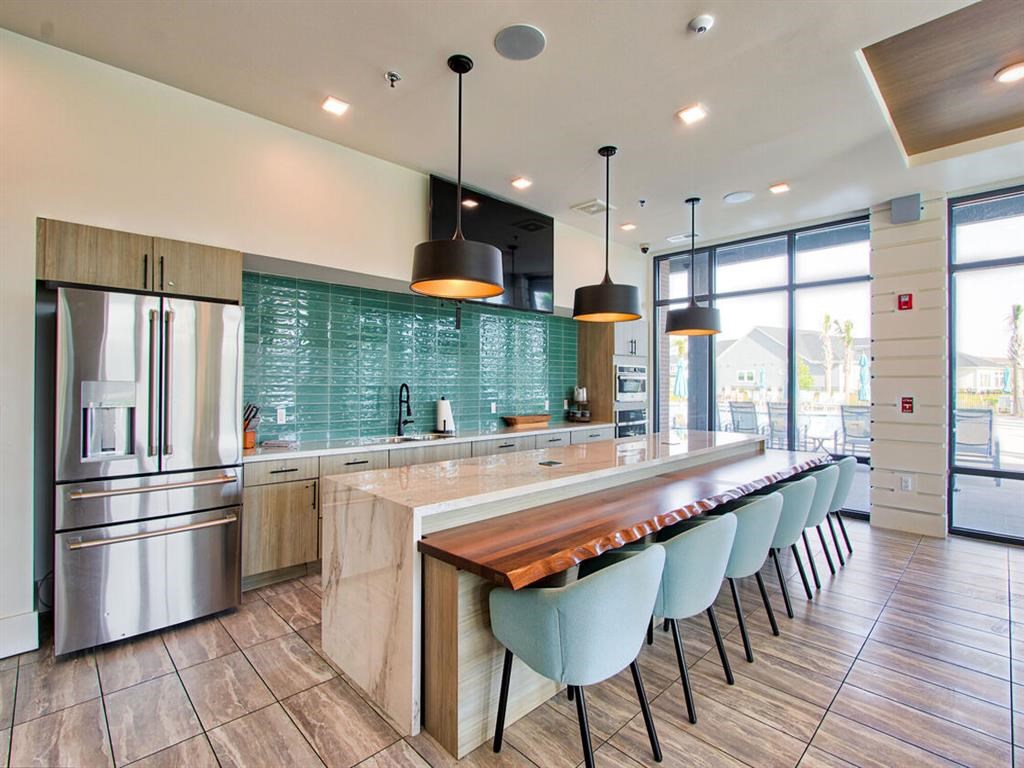 a large kitchen with a long bar and chairs