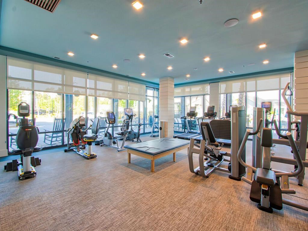 a gym with a lot of exercise equipment and windows