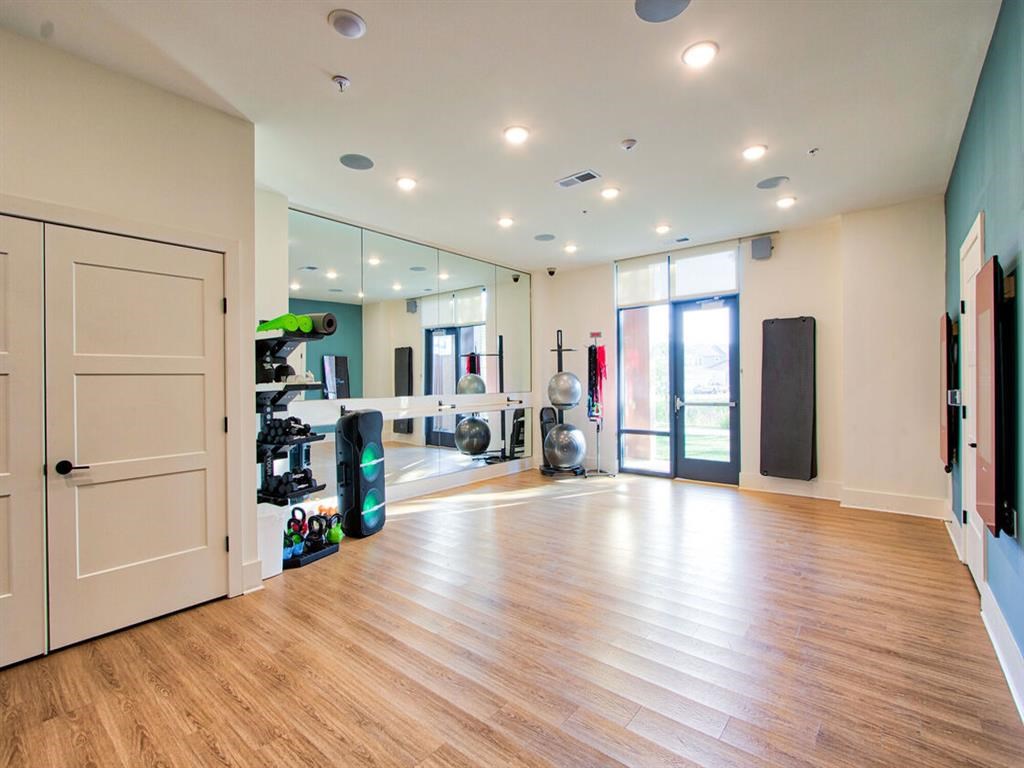 a workout room with mirrors on the wall and a wooden floor