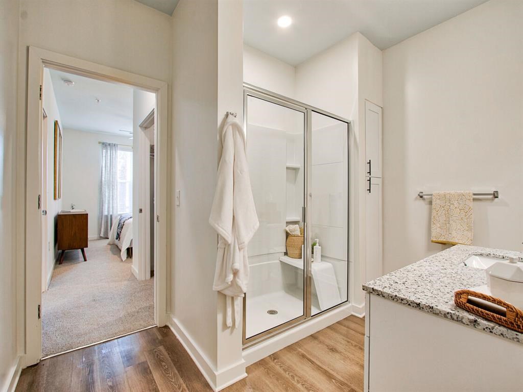 a bathroom with a shower and a sink and a mirror