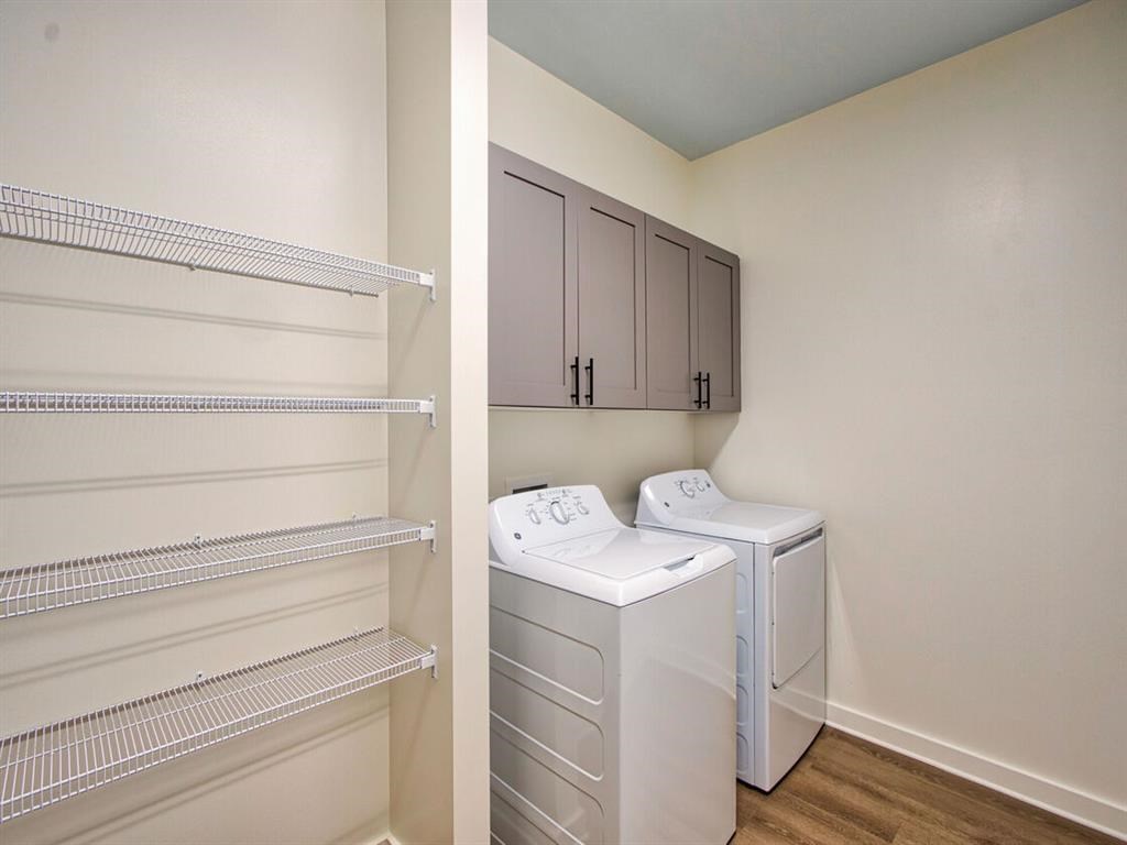 a laundry room with two washers and a dryer