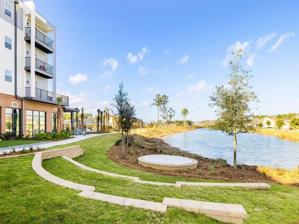 a park with a river next to a building