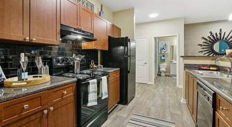A kitchen with black appliances and wooden cabinets.