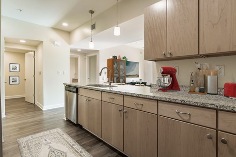 A kitchen with wooden cabinets and a red mixer.