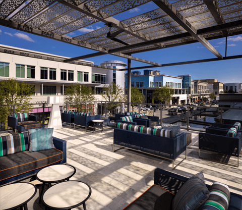 A sunny day at an outdoor seating area with tables and chairs.