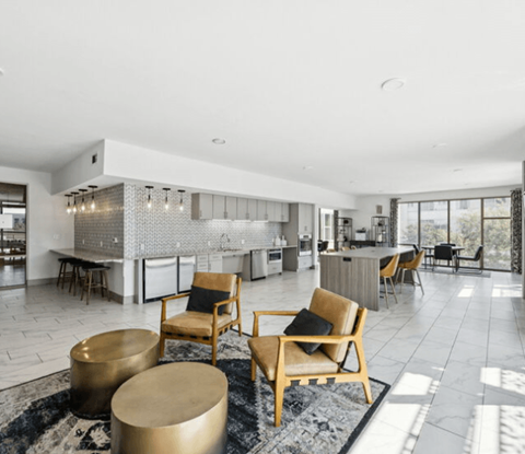 A modern living room with a kitchen in the background.