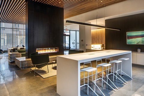 A modern kitchen with a white counter and bar stools.