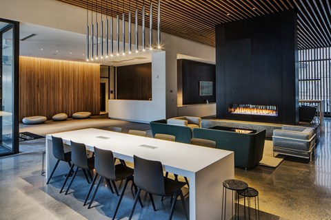 A modern dining room with a long table and chairs.