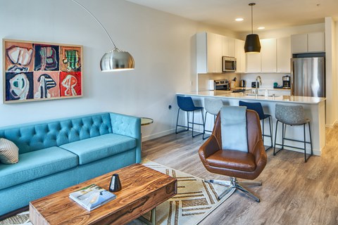 A modern living room with a blue couch and a wooden coffee table.