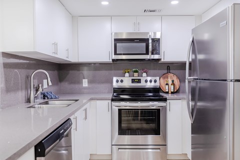 a modern kitchen with stainless steel appliances and white cabinets