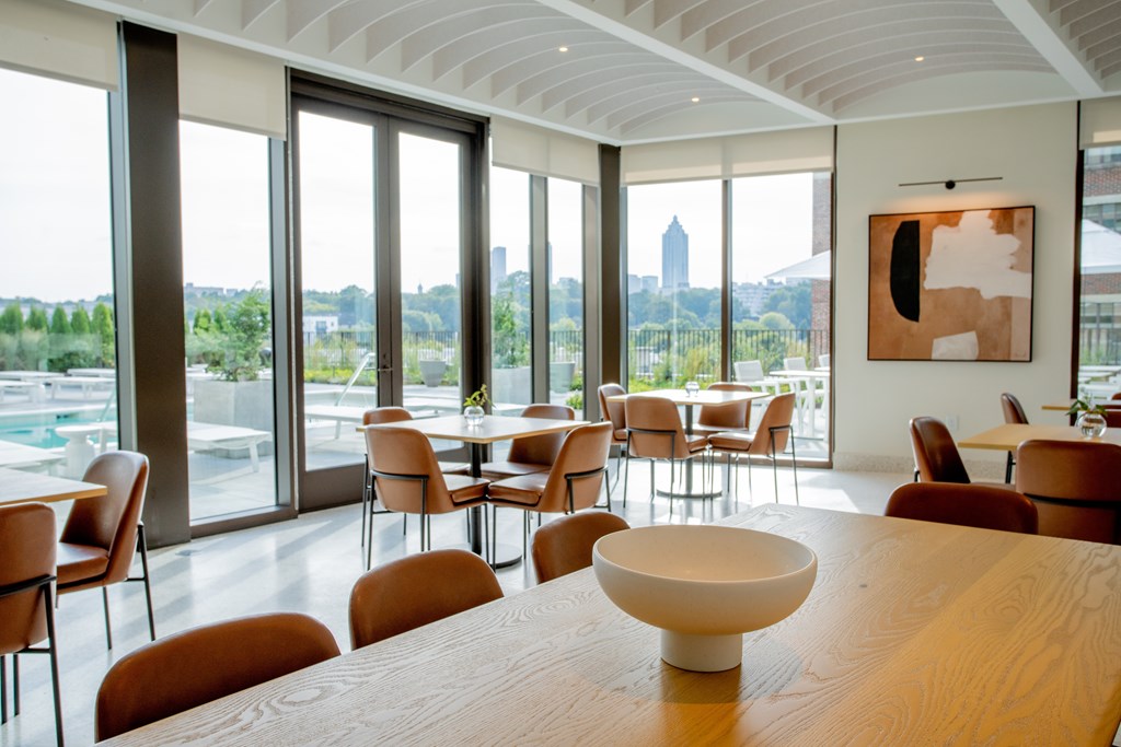 a dining room with tables and chairs and a view of a city