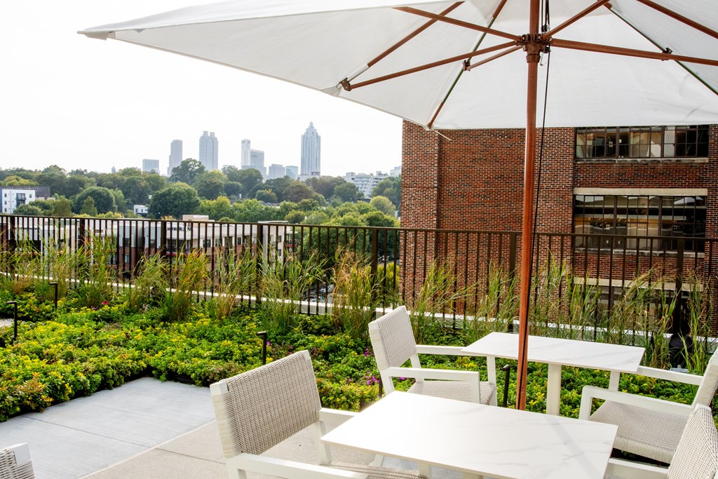a patio with chairs and an umbrella and a view of the city