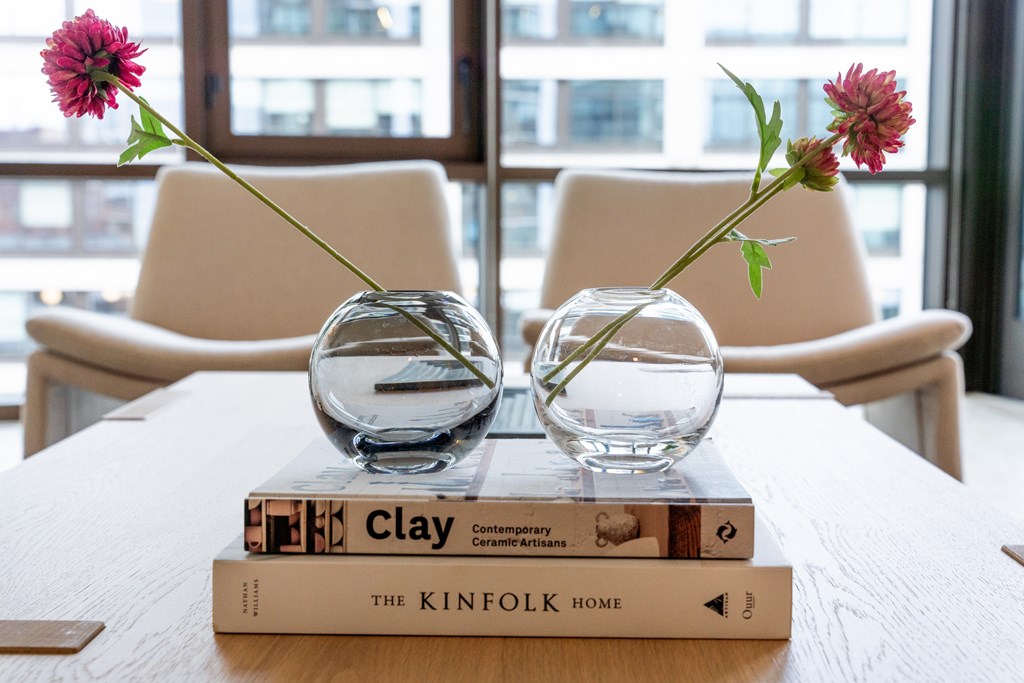 two vases on top of a stack of books on a table