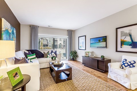 A living room with a white couch, a coffee table, and a painting on the wall.