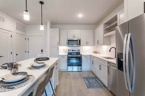 A modern kitchen with a dining table set for two.