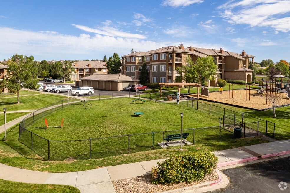 a park with a playground and apartments in the background