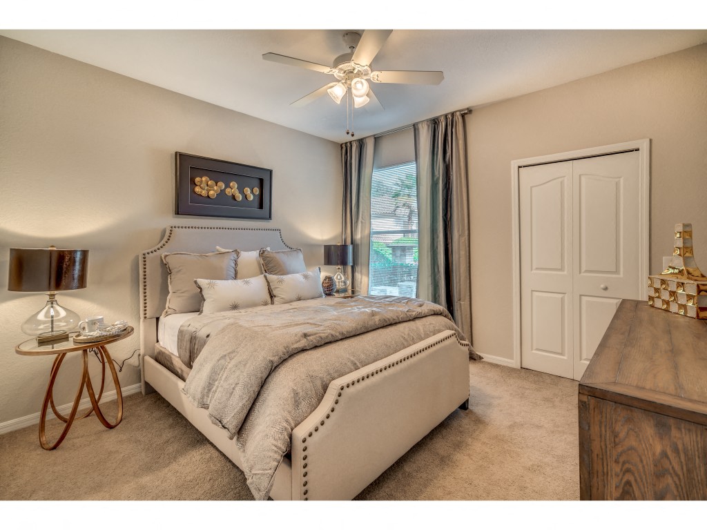 a bedroom with a bed and a ceiling fan