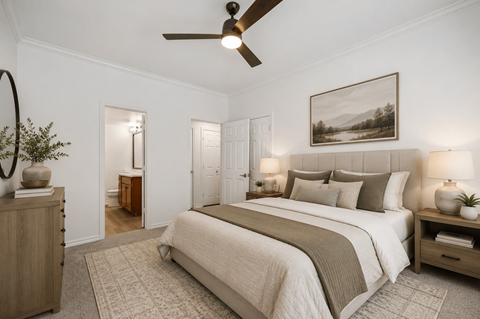 A bedroom with a large bed and a ceiling fan.