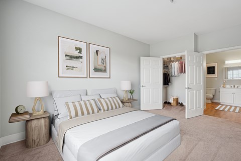 A bedroom with a large bed and two lamps.