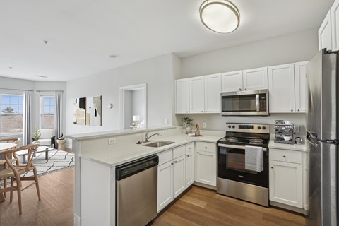 A modern kitchen with white cabinets and stainless steel appliances.