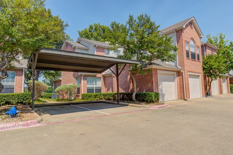 A large brick house with a covered parking area in front.