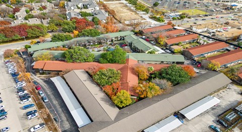 An aerial view of a parking lot and buildings with trees in autumn colors.