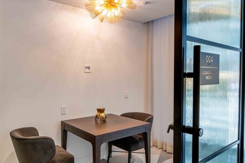 a conference room with a table and chairs next to a glass door
