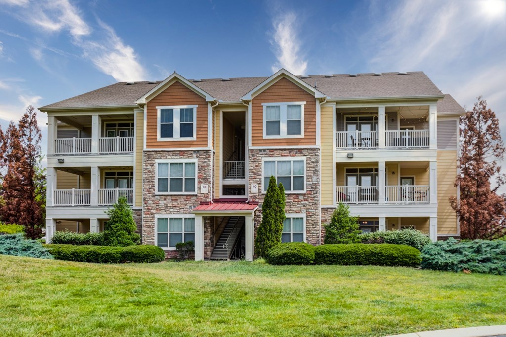 an apartment building with a green lawn in front of it