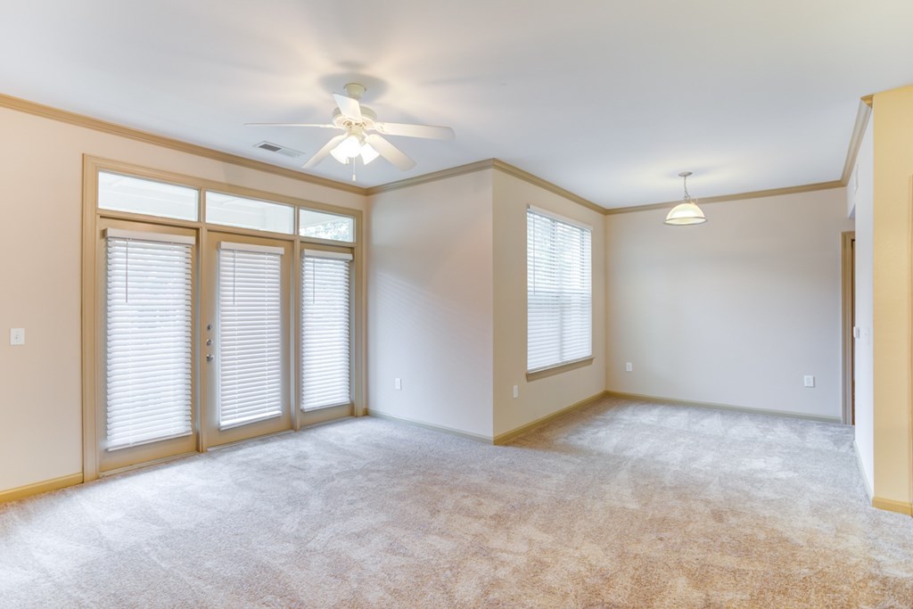 an empty living room with a ceiling fan