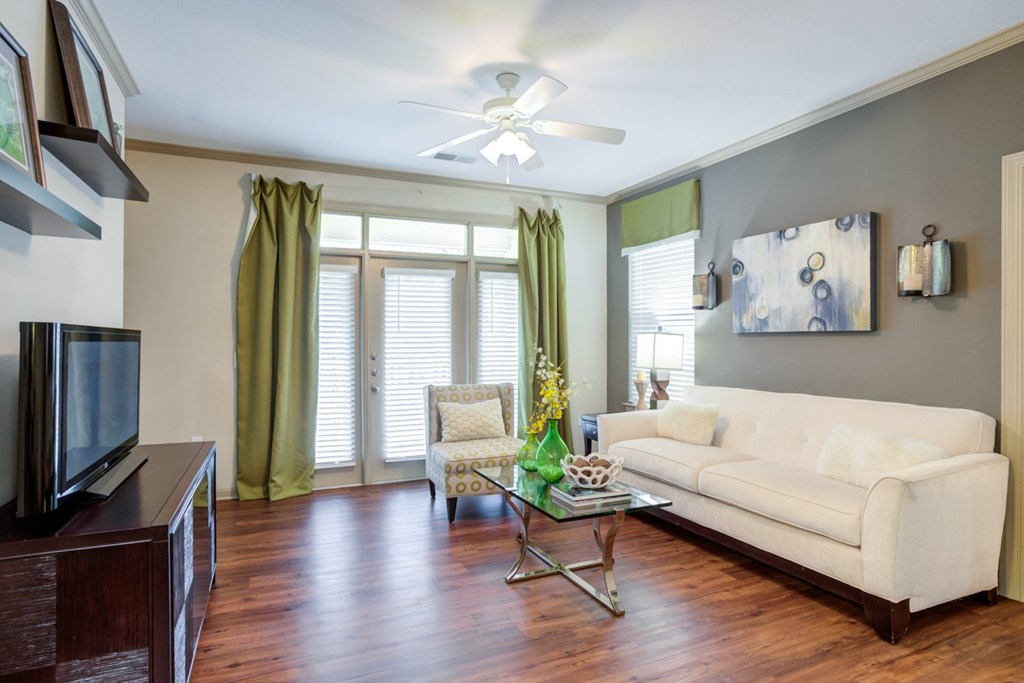 Apartments For Rent In Hendersonville, TN - The Grove At Waterford Crossing - Living Room With Couch, Chair, Coffee Table, TV Stand, And Window.