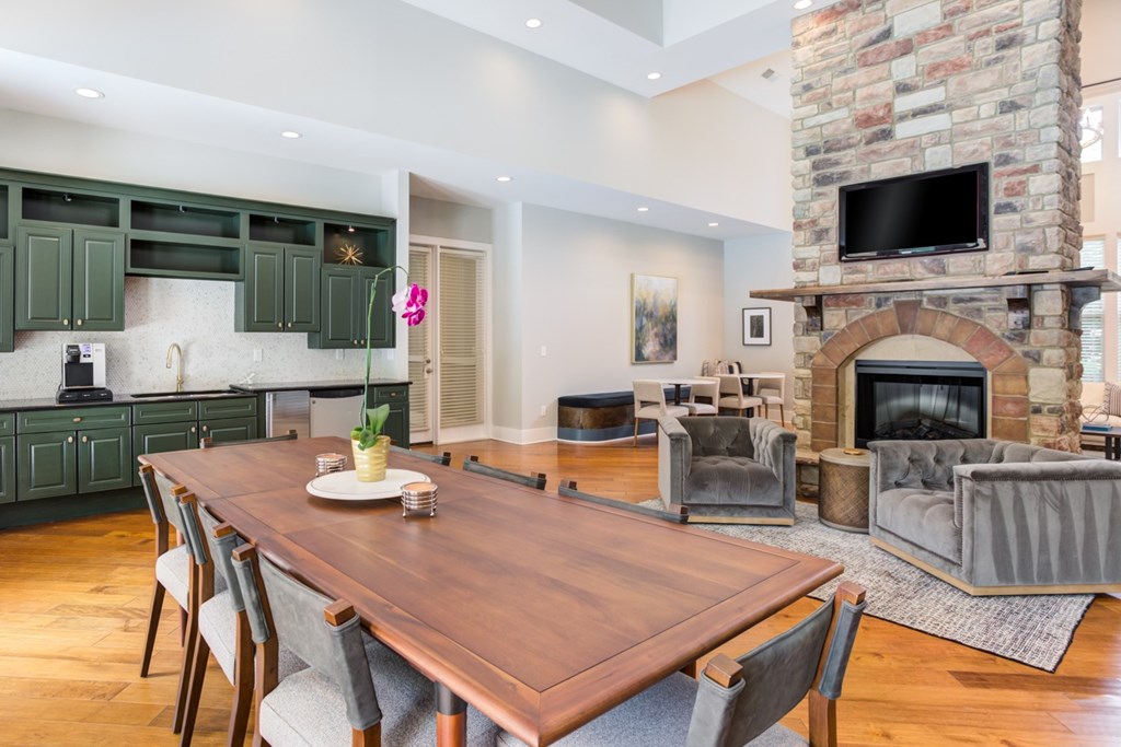 a dining area with a wooden table and chairs and a fireplace with a tv above it