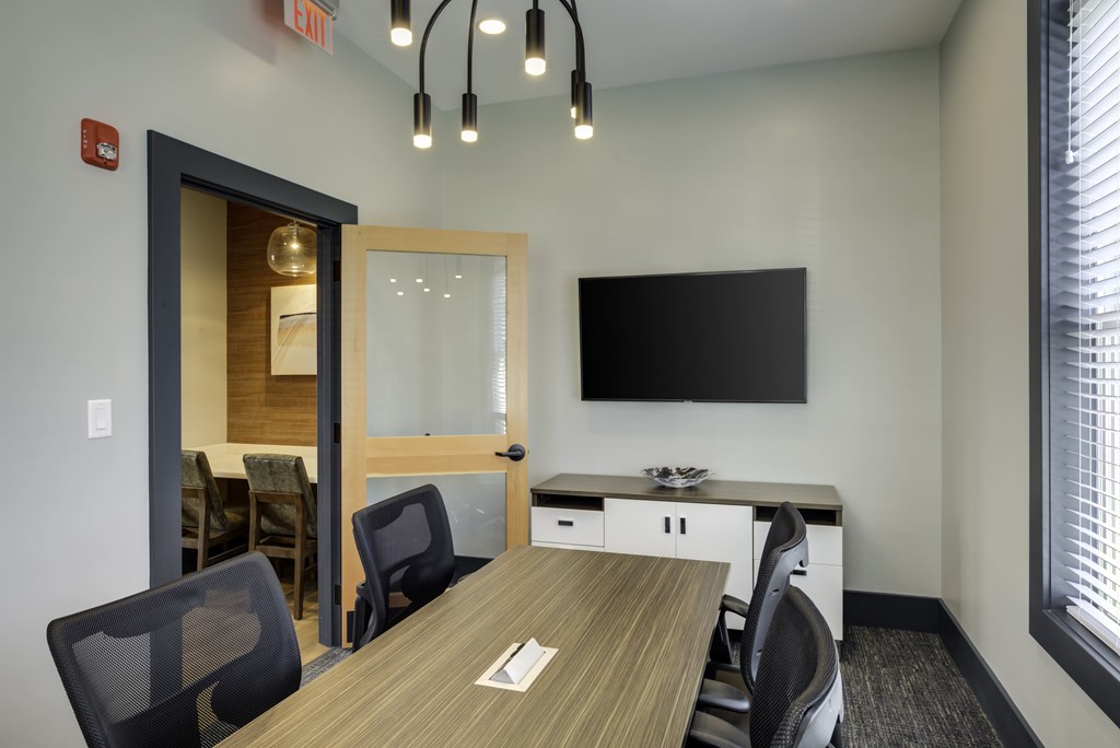 A conference room with a long table and chairs.